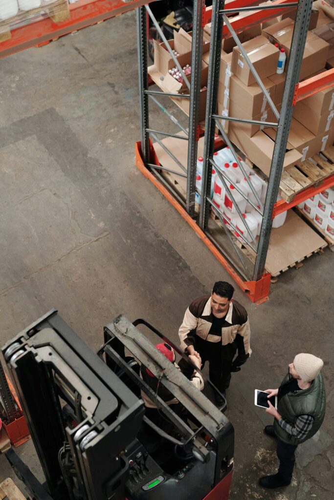 pexels-photo-4483555-4483555 High angle view of staff collaborating in a warehouse, showcasing teamwork and logistics.